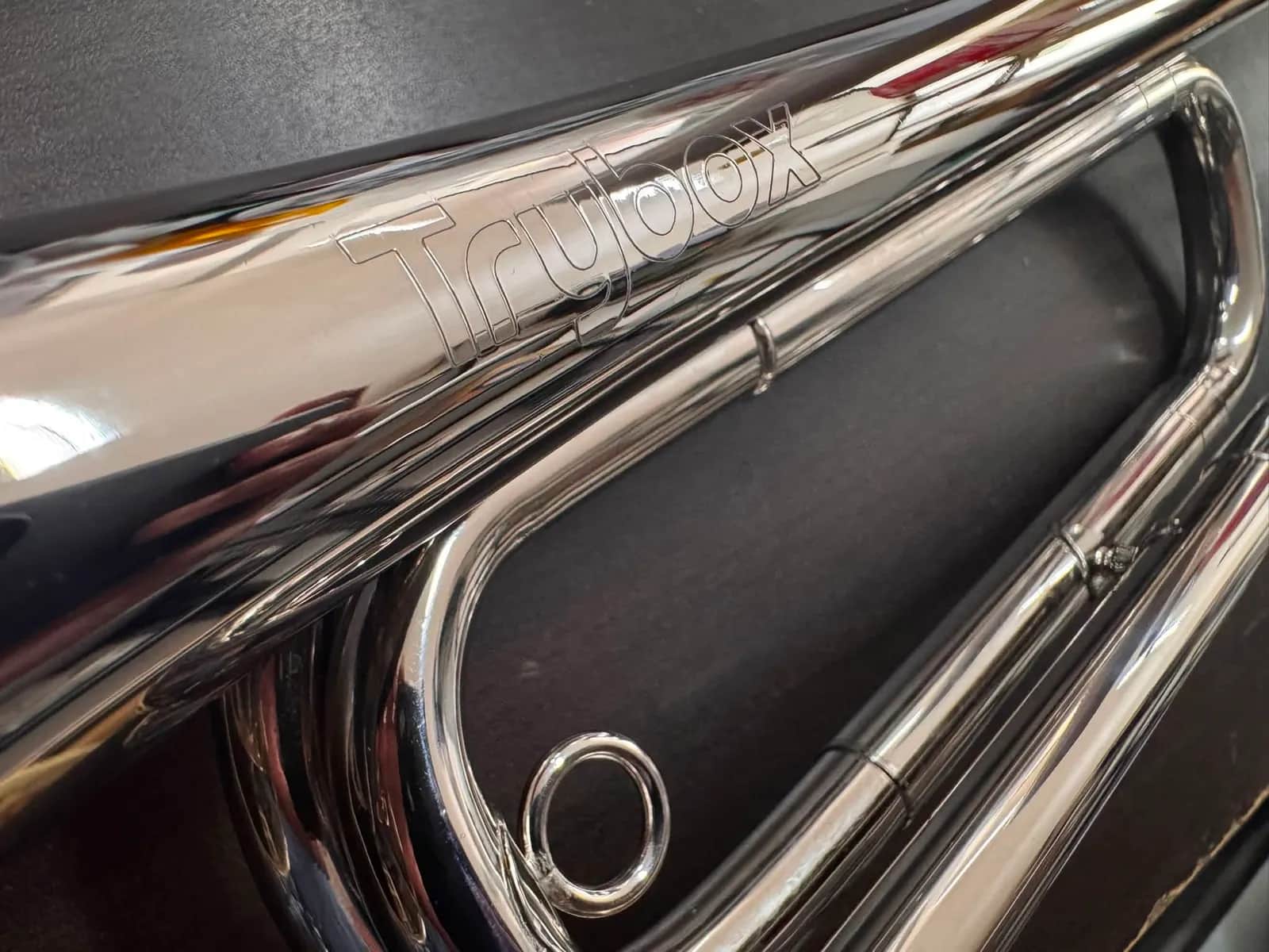 Close-up of a chrome bugle engraved with the Trybox name